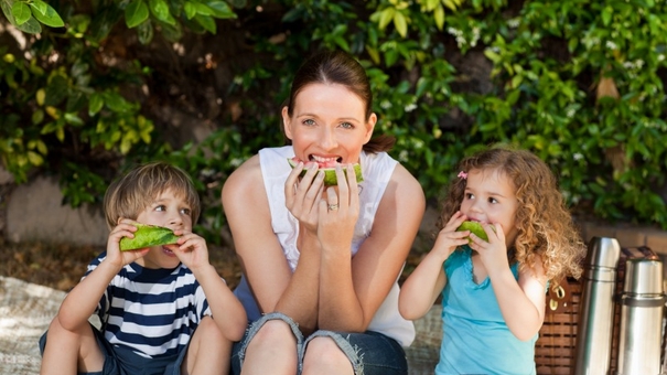 Mom and two children eating watermelon