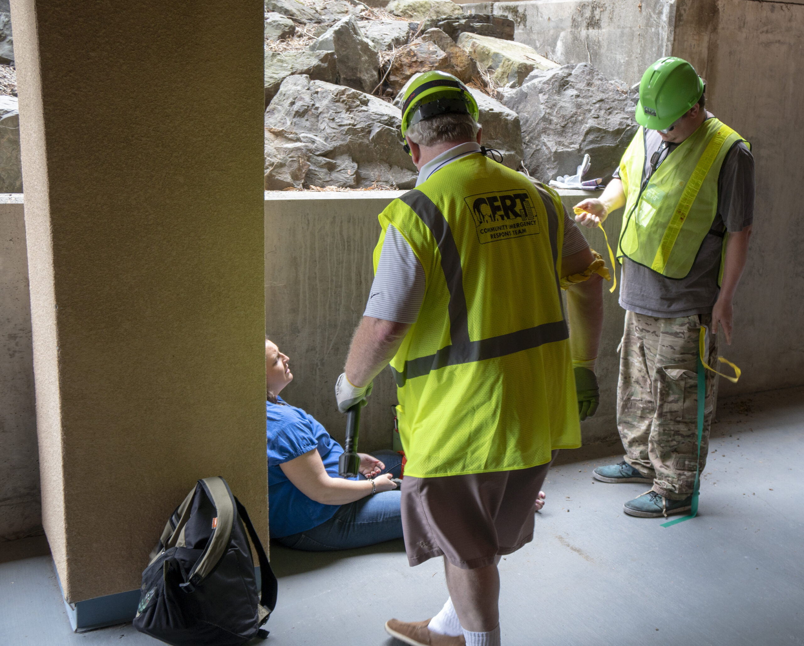 two cert members standing next to an actor posing as a patient in between building pillars